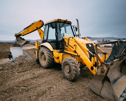close up details of massive working machinery, industrial backhoe loader with excavator on construction site